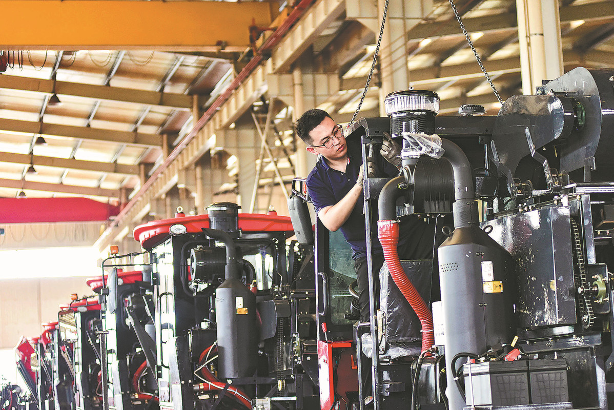 An employee works on the production line of a combine harvester manufacturer in Qingzhou, Shandong province